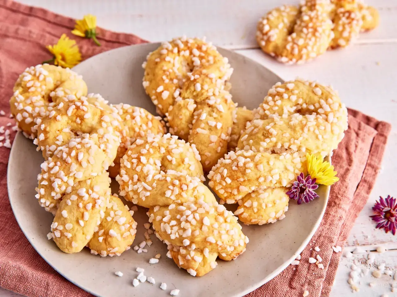 Landfrauen Rezept: Flachswickel, zarte Kekse mit Zuckerkristallen, dekoriert mit Blumen.