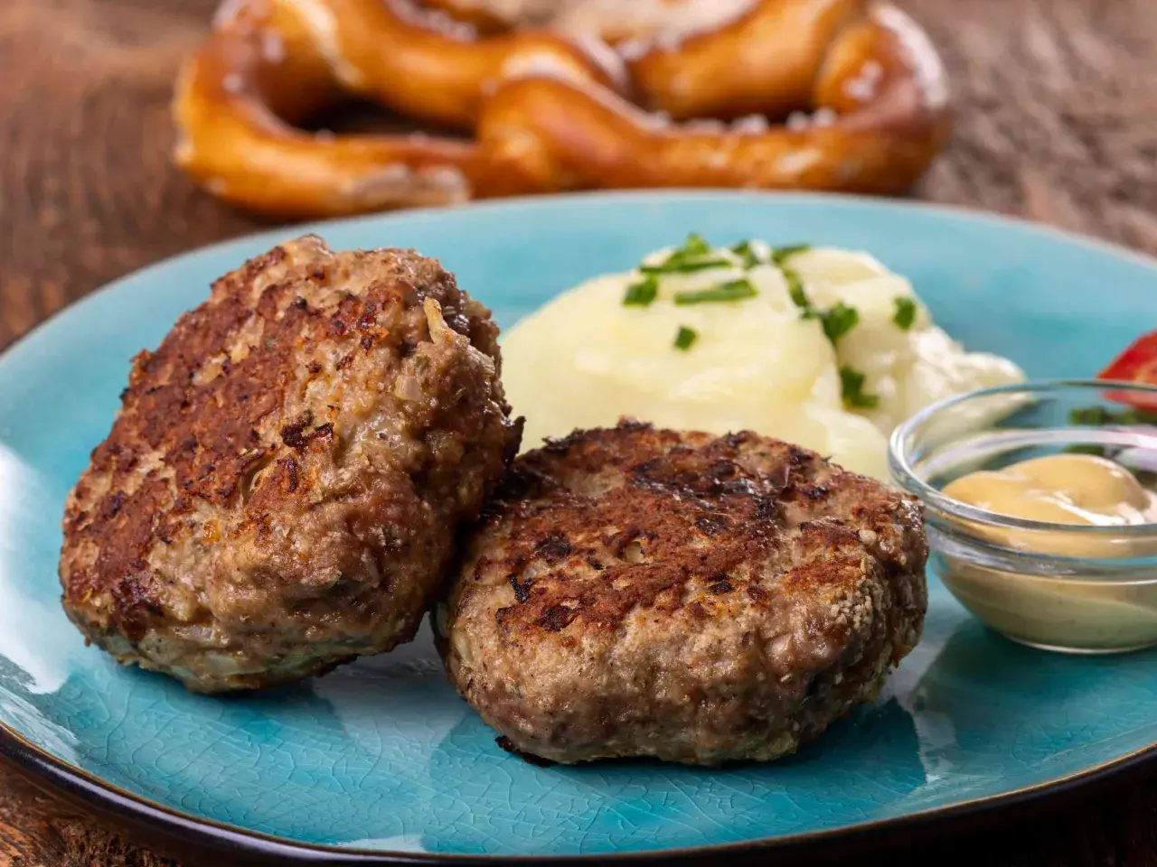 Zwei goldbraune Frikadellen mit Kartoffelbrei und Senf. Dieses Gericht ist ein Beweis für das beste Frikadellen Rezept, das man sich wünschen kann.