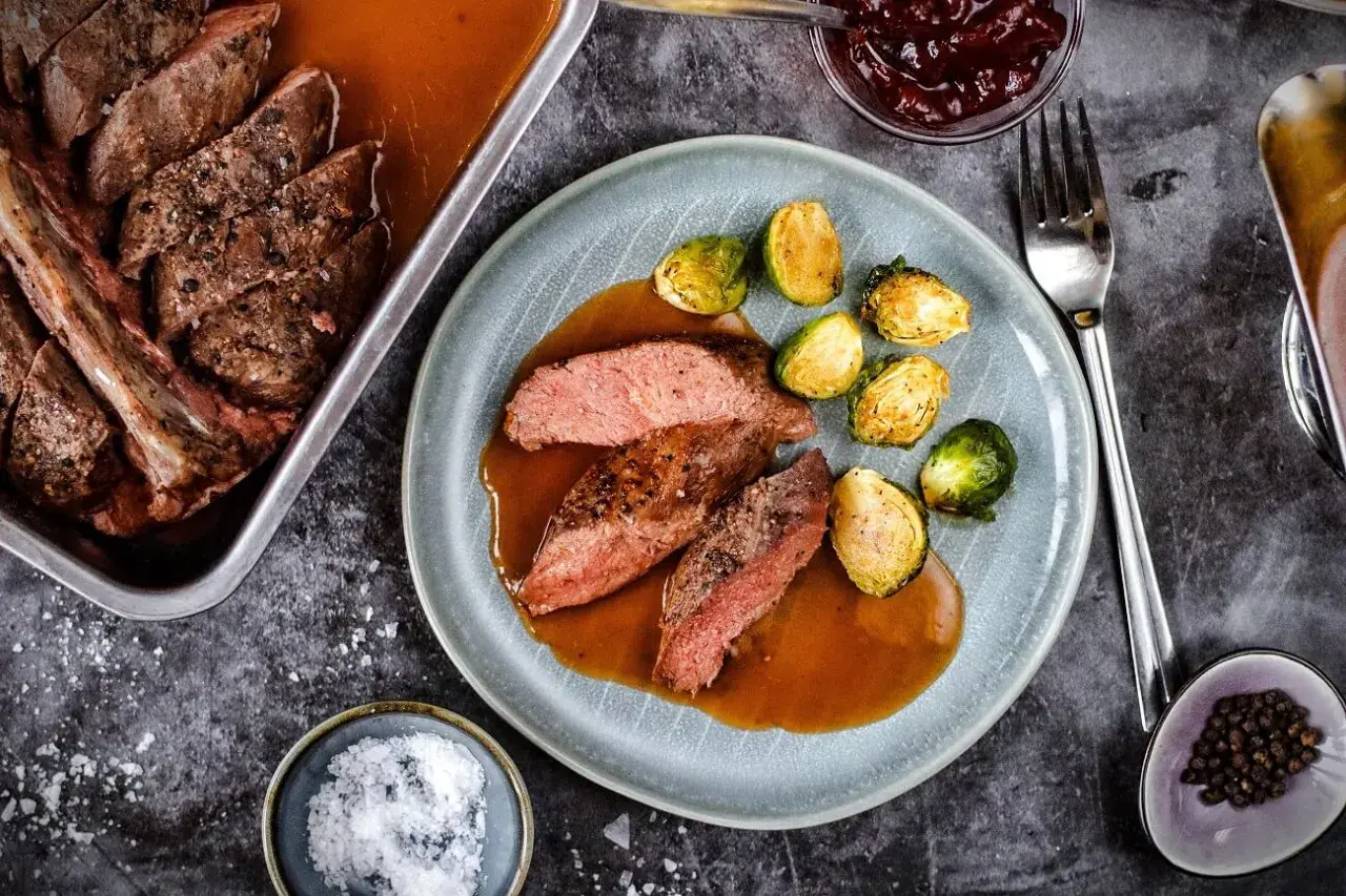 Zart geschnittener Rehbraten in Rotwein-Sauce mit Rosenkohl. Ein Festmahl, das auf der Zunge zergeht.
