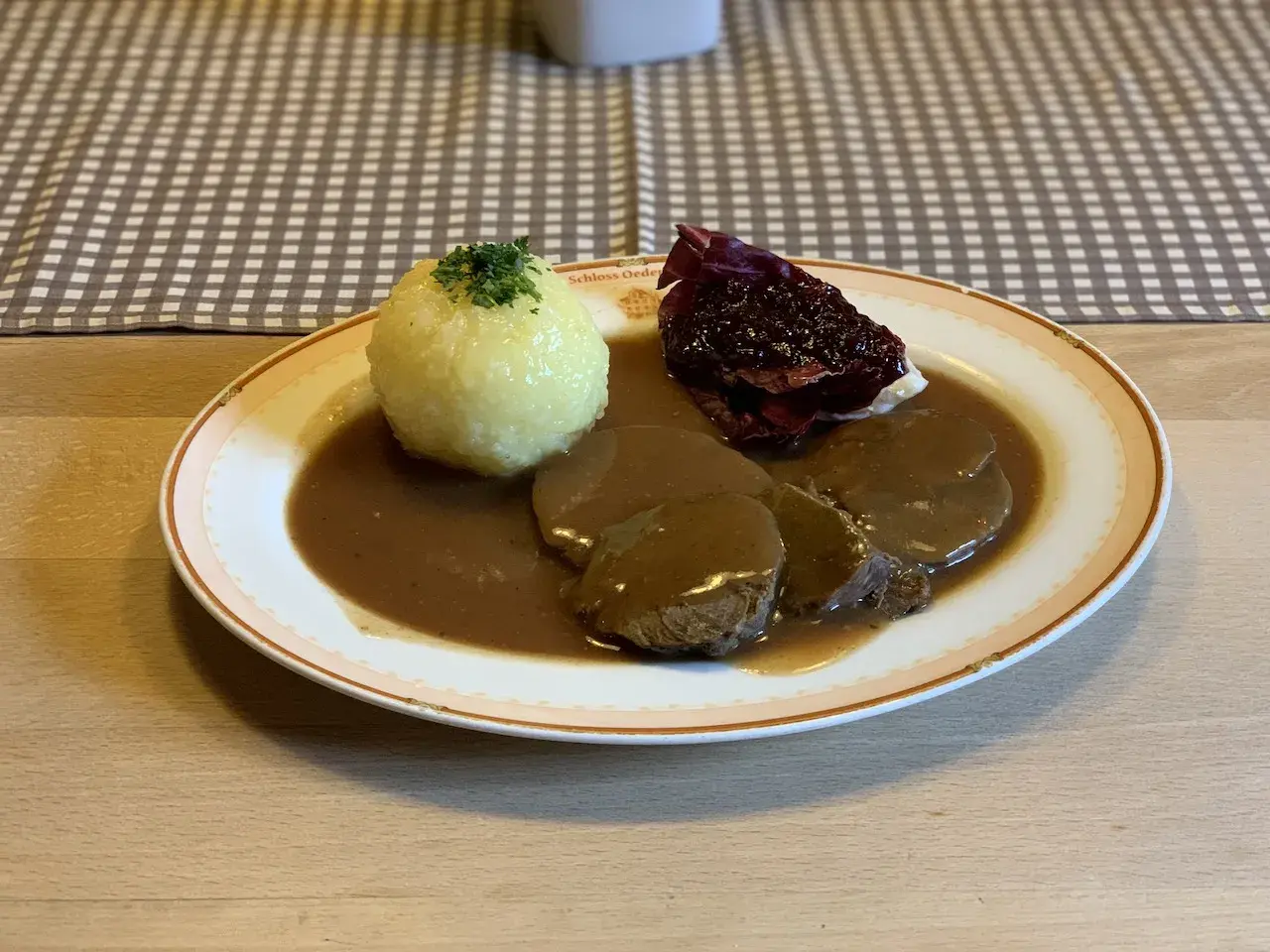 Deftig geschmortes Rindfleisch in dunkler Sauce mit Klößen und Rotkohl. Ein Klassiker, der an Omas **Treber Rezepte** erinnert.