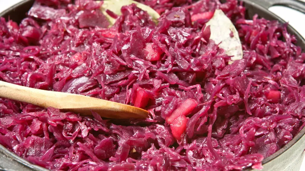 Leckeres rotkohl rezept aus dem glas, mit Apfelstücken und Lorbeerblättern, bereit zum Servieren.
