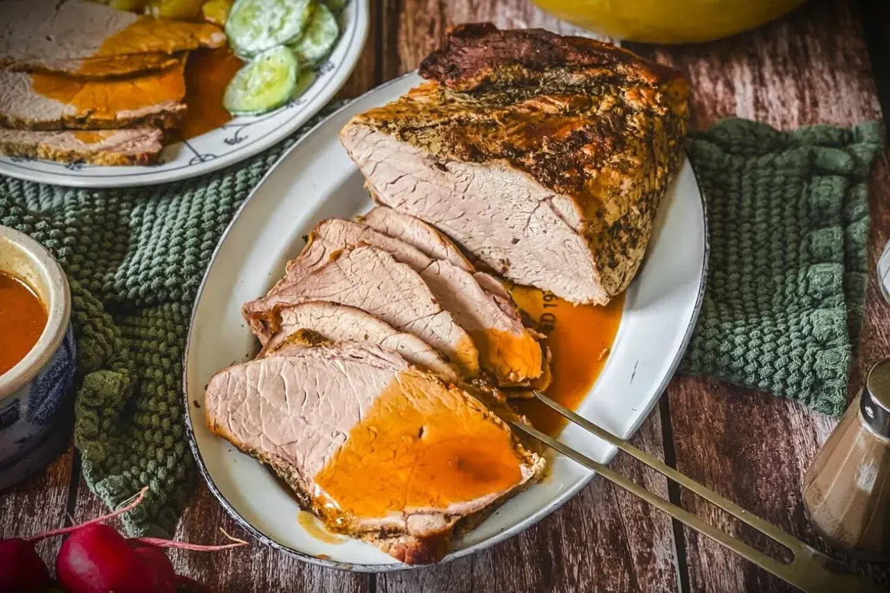 Saftiger Schweinebraten, perfekt gegart bei der richtigen Schweinebraten Temperatur Umluft. Serviert mit Sauce und Beilagen.