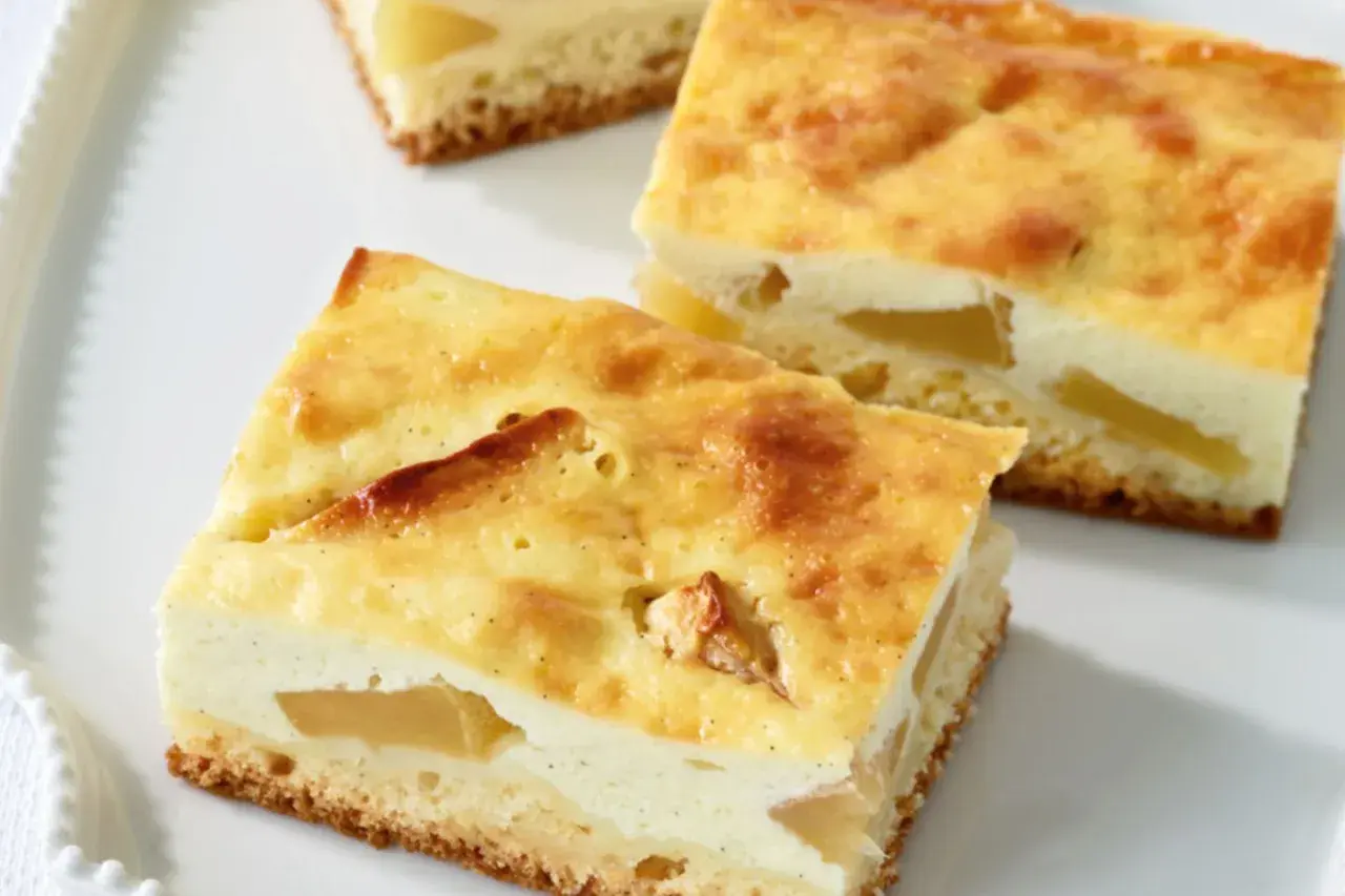 Saftiger Apfelkuchen aus der Kastenform mit einer cremigen Quarkschicht und zarten Apfelstücken.