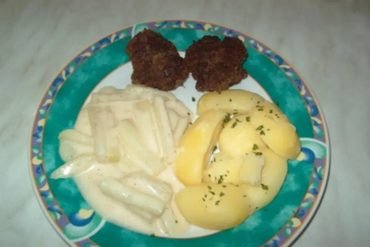 Zwei Frikadellen mit Salzkartoffeln und Kohlrabi in heller Soße. Ein leckeres Gericht, das zeigt, wie vielseitig Kohlrabi Rezepte sein können.