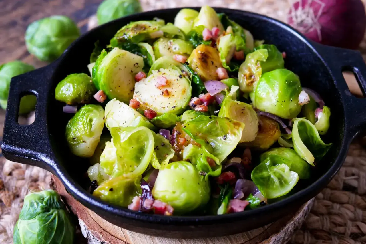 Gebratener Rosenkohl mit Speck und Zwiebeln in einer Gusseisenpfanne &ndash; ein Beweis f&uuml;r schnelle Gerichte mit Rosenkohl.