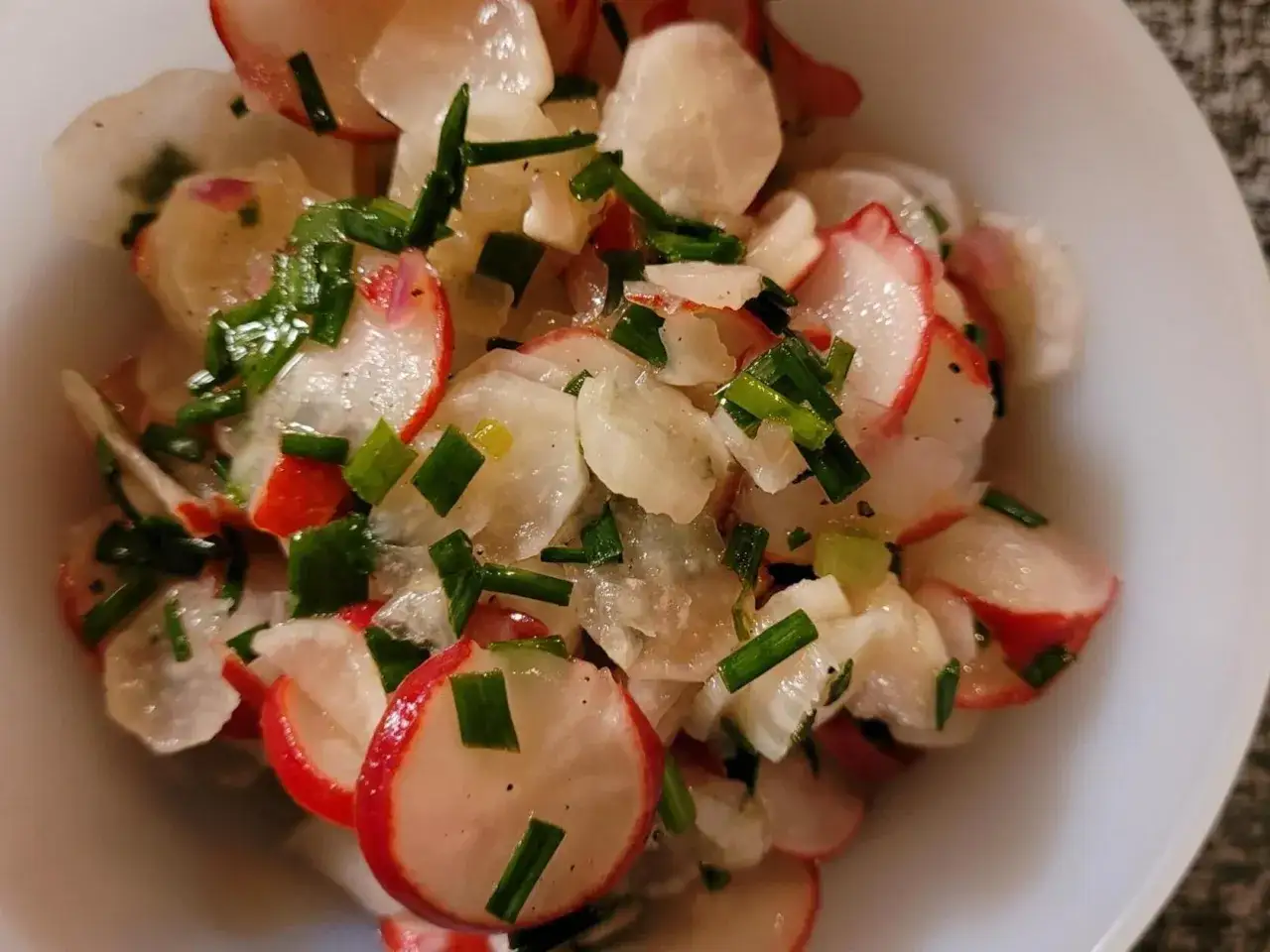 Frischer Salat mit fein geschnittenen Radieschen und Schnittlauch.