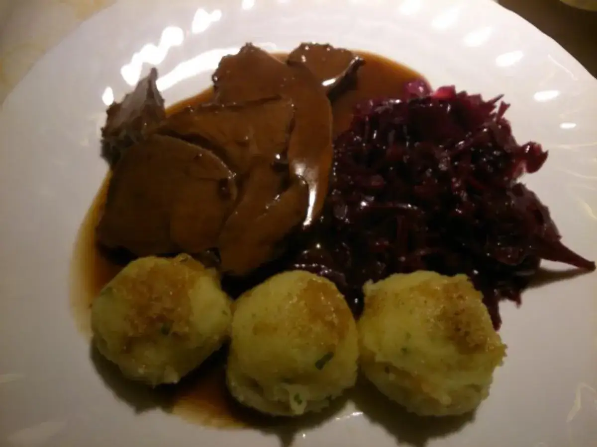 Rehbraten in Rotwein eingelegt, serviert mit Rotkohl und Kartoffelkl&ouml;&szlig;en. Ein Festmahl!
