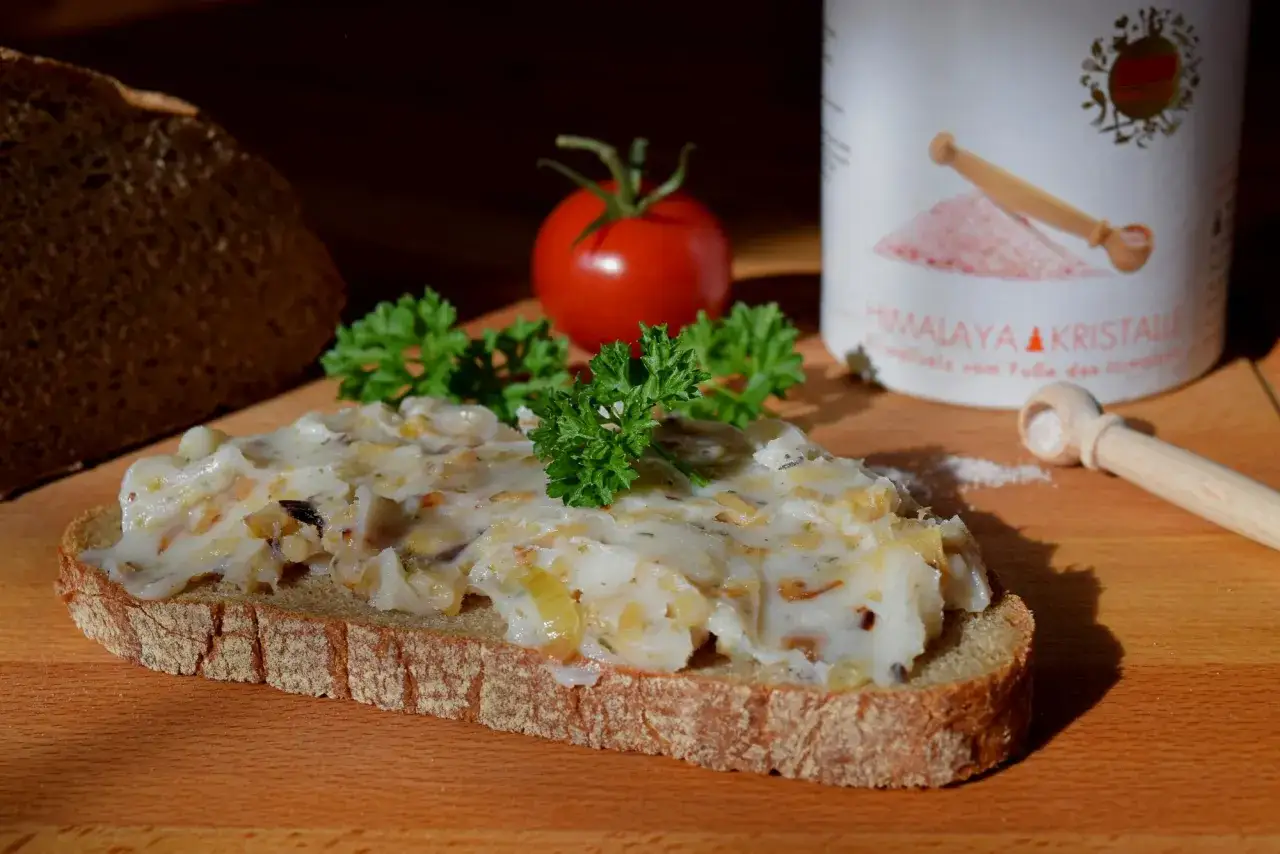 Herzhaftes Griebenschmalz Rezept auf Bauernbrot, garniert mit Petersilie und Tomate. Ein Genuss!