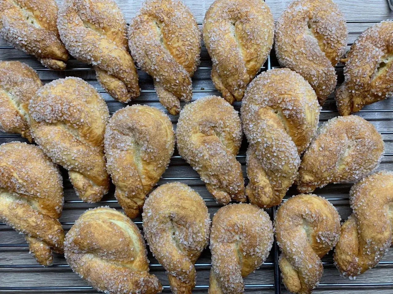 Goldbraune, gezuckerte Flachswickel, ein klassisches Landfrauen Rezept, liegen auf einem Gitter.