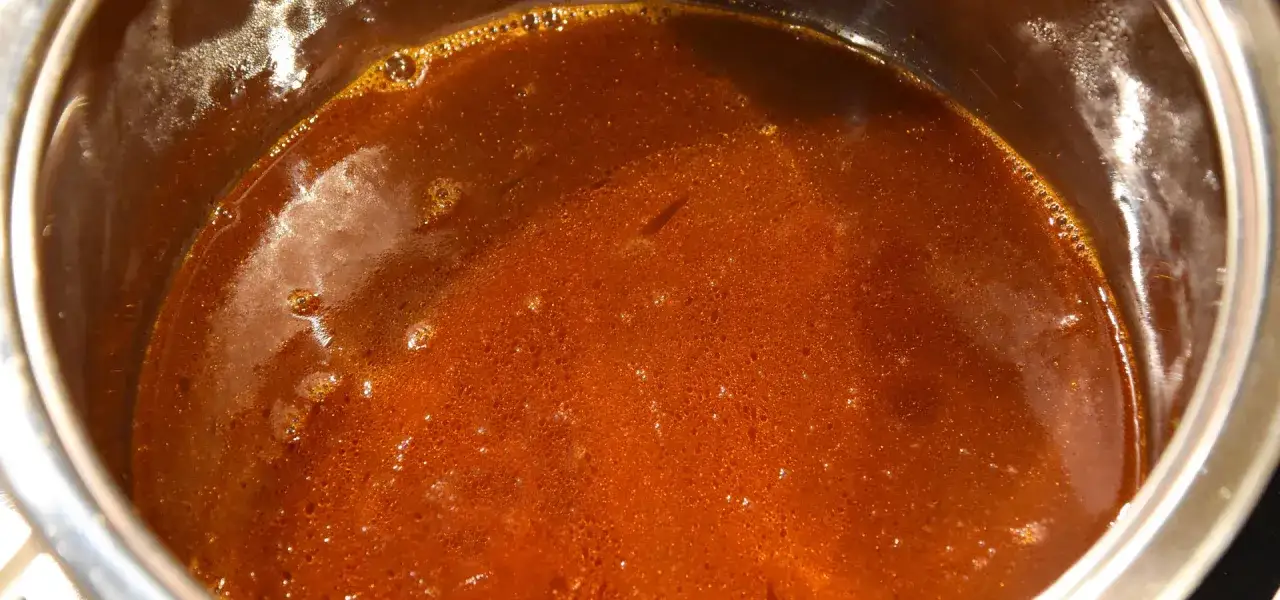Eine k&ouml;stliche, dunkle Grundsauce blubbert in einem Topf. Sie duftet nach herzhaften Aromen und ist bereit, Gerichte zu verfeinern.
