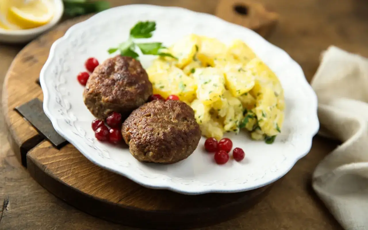 Zwei saftige Frikadellen mit Kartoffelsalat und Preiselbeeren &ndash; das beste Frikadellen Rezept f&uuml;r einen herzhaften Genuss.