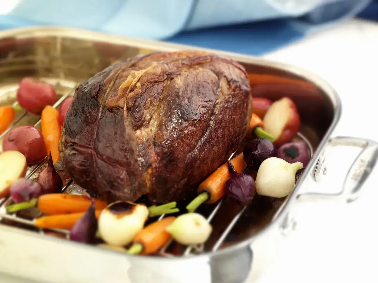 Ein 1,5 kg Rinderbraten schmort mit Wurzelgem&uuml;se in einer Bratreine.