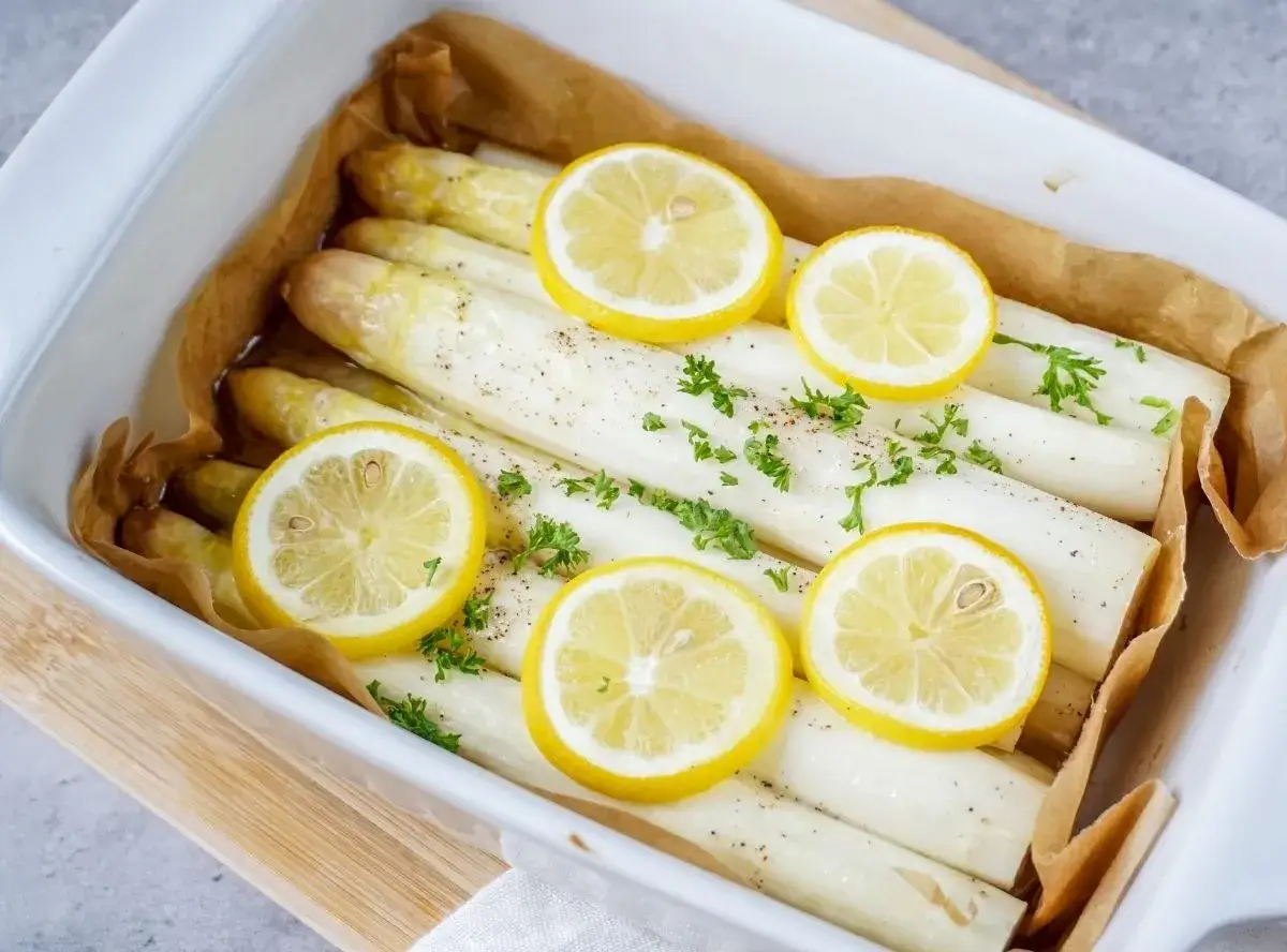 Zubereitung gefrorener Spargel im Backofen: Wei&szlig;er Spargel mit Zitronenscheiben und Petersilie in einer Auflaufform.