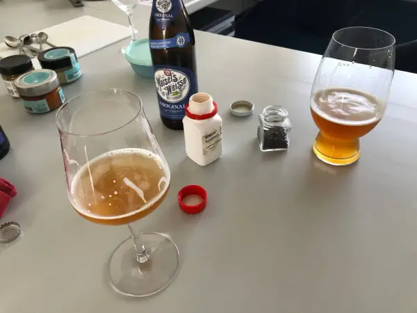 Zwei Gläser Weizenbier, eine Flasche Maisel's Weisse und kleine Gläser mit Gewürzen. Der Weizenbier Geschmack wird durch die Zutaten verfeinert.